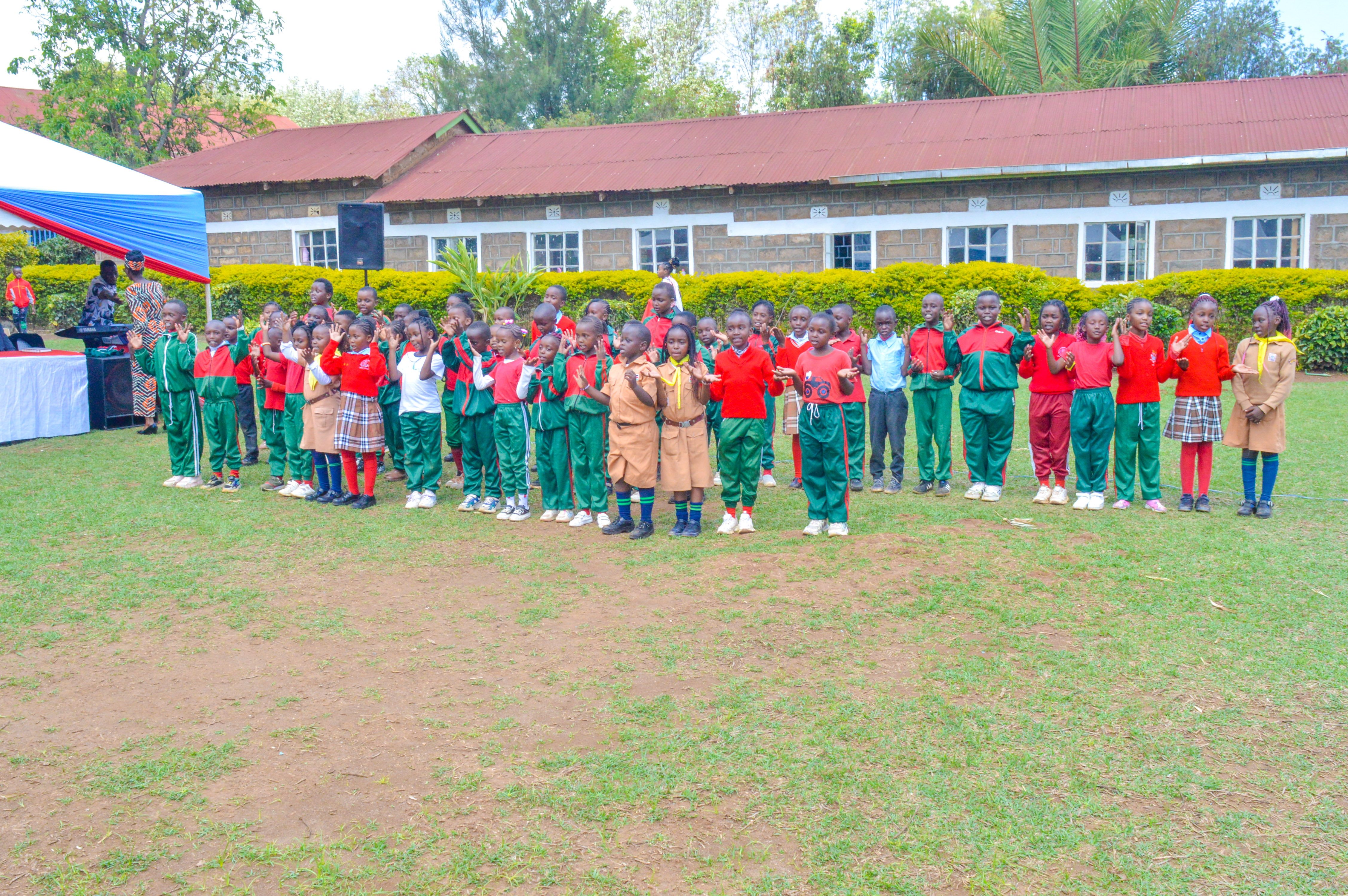 Large group of learners performing on the field