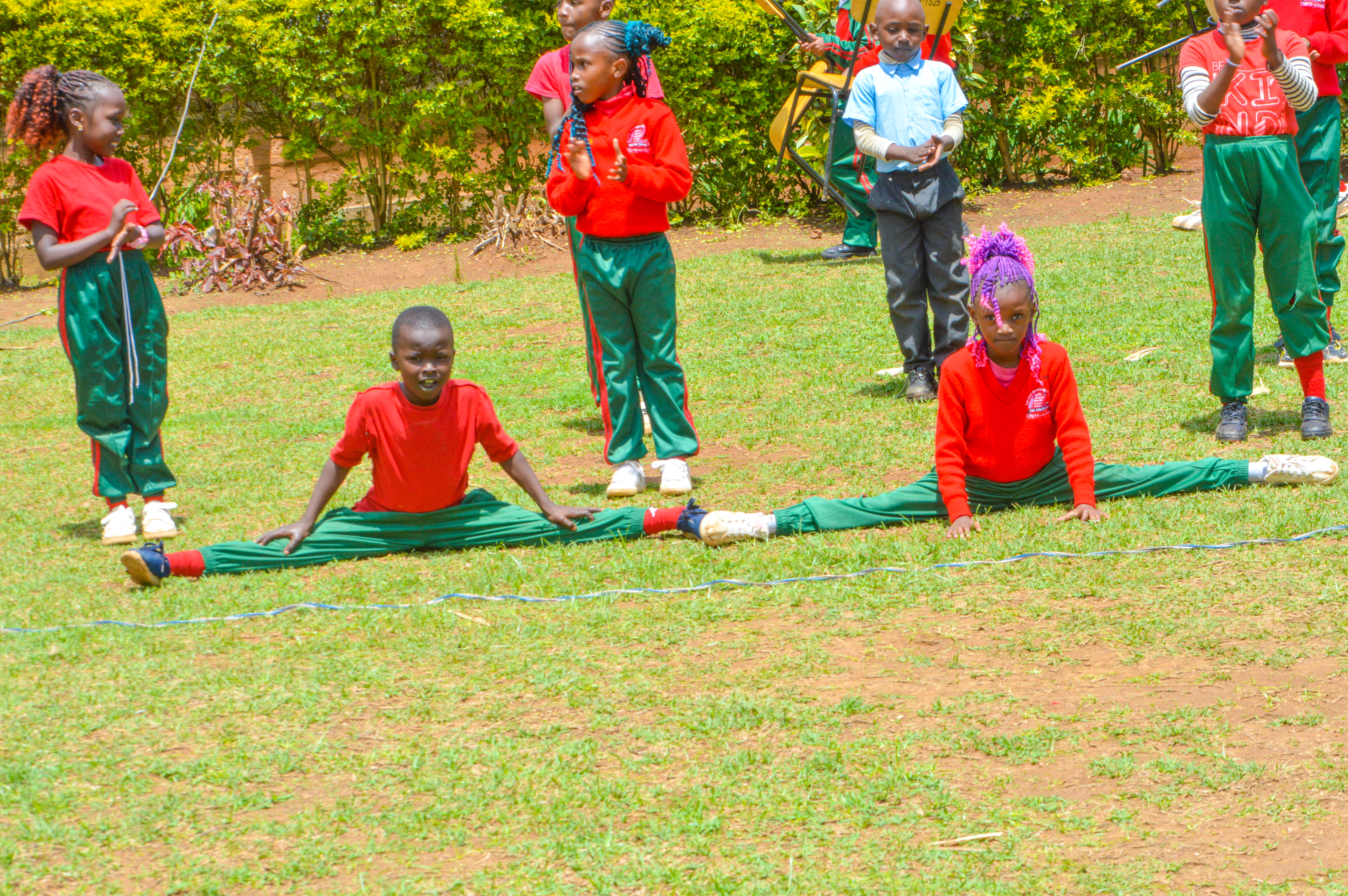 Children doing gymnastics splits on the school field