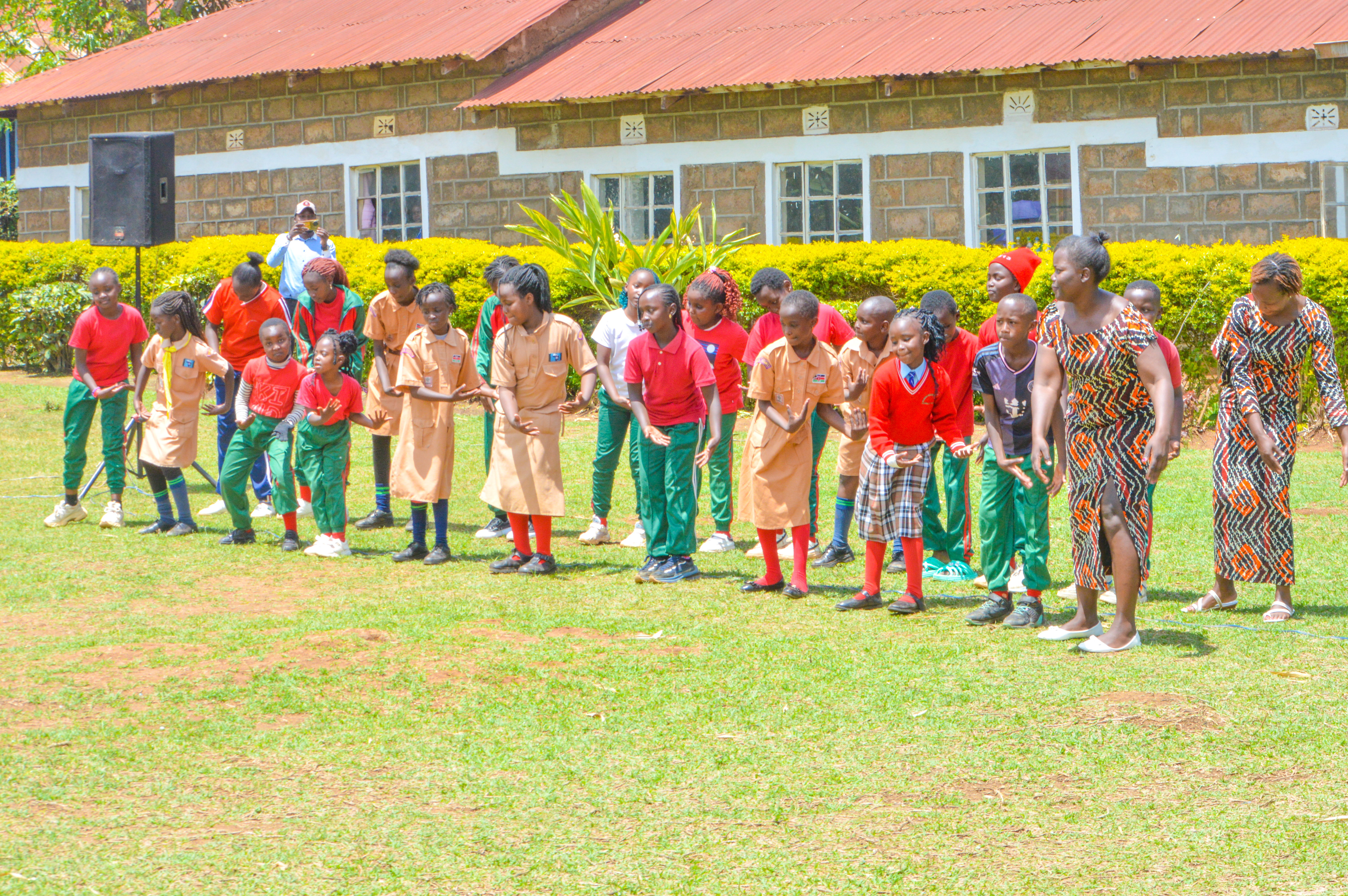Learners performing cultural dance with teacher
