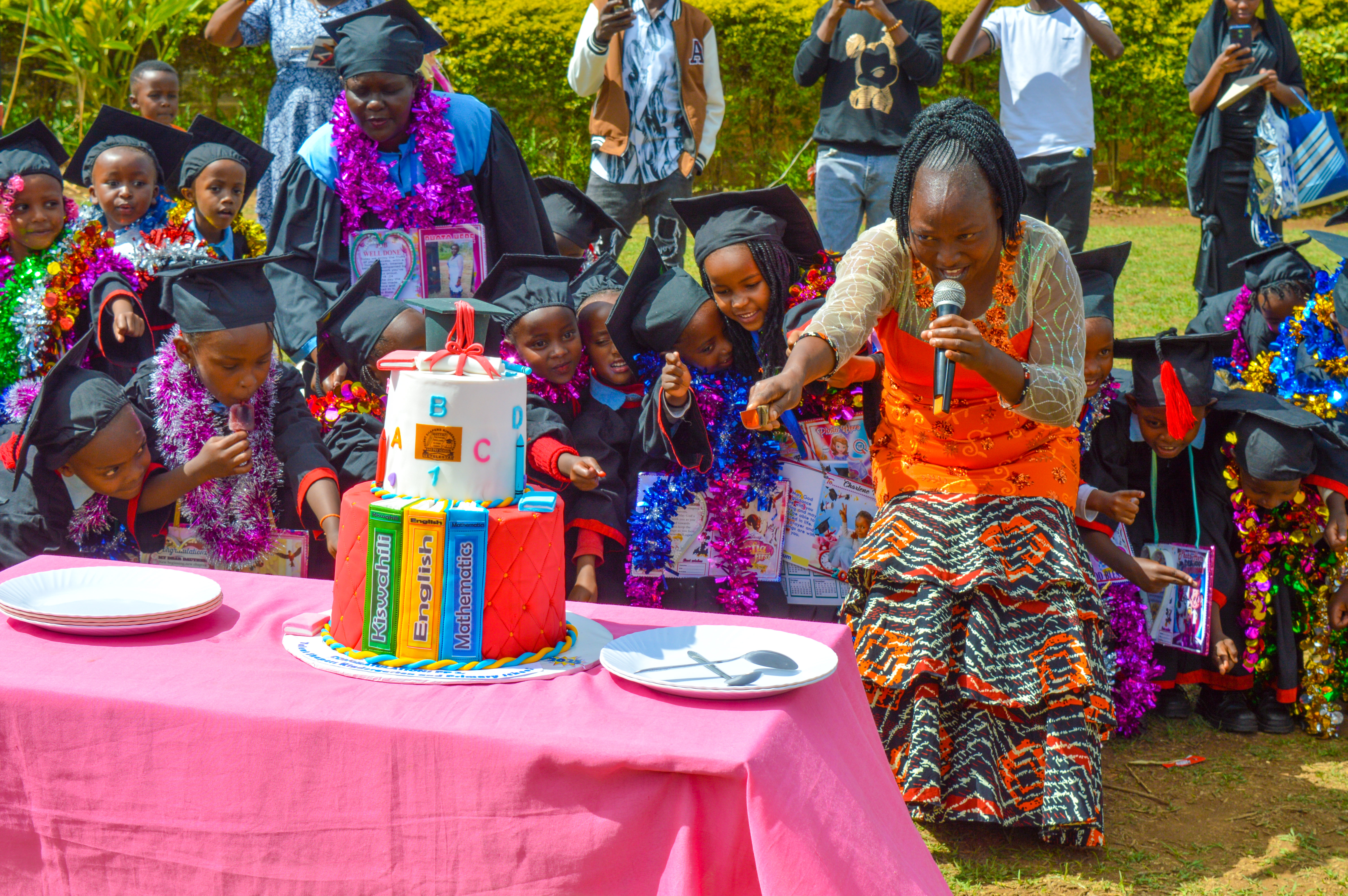 Graduation cake cutting ceremony with graduates